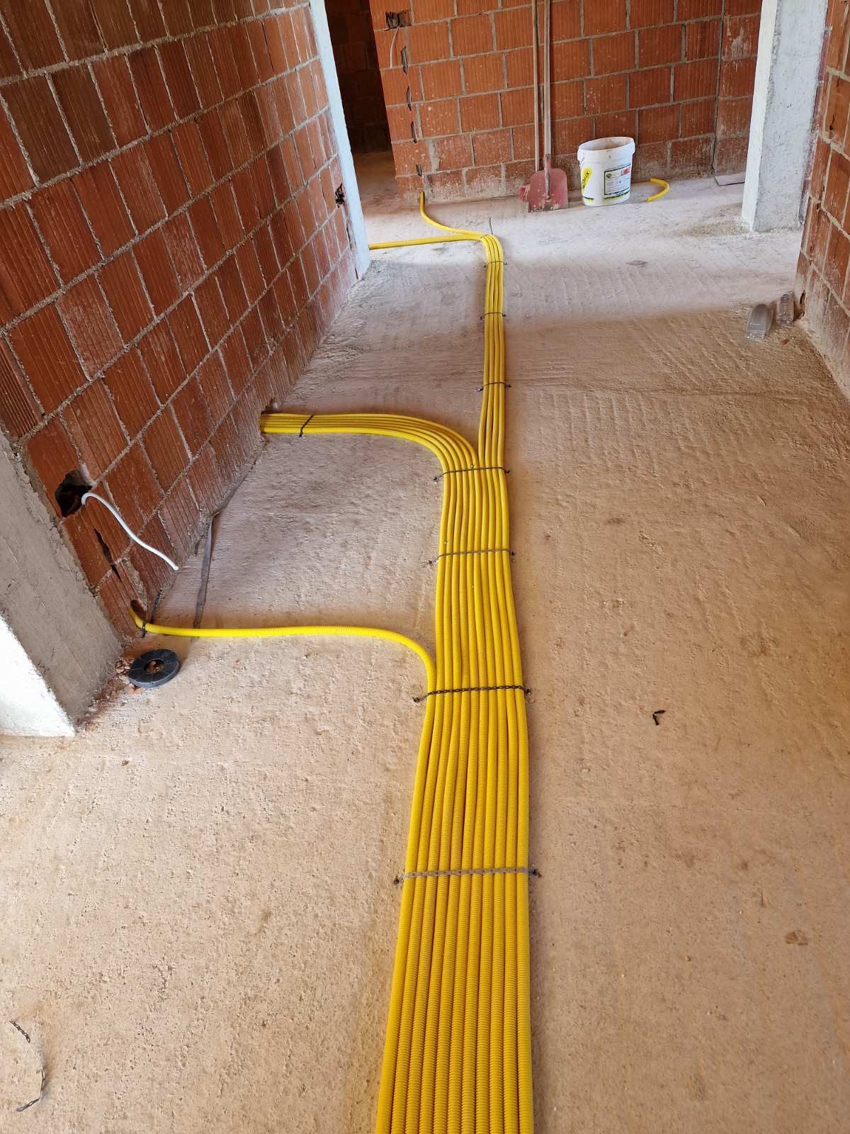 Tuba elektrikë të verdhë të fiksuar me precizion në dysheme betoni